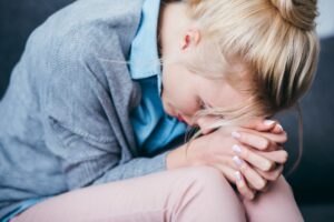 Woman leaning over with hands folded